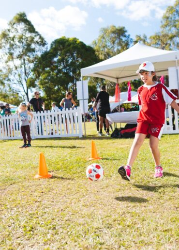 a boy kicking a football ball