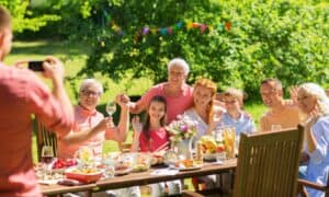 Multi-generational family posing for a photo at a backyard summer barbecue or party.
