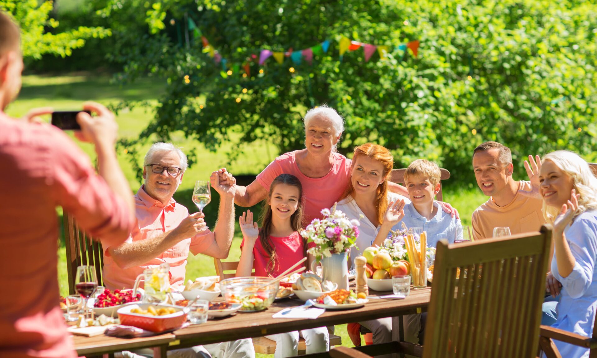 Multi-generational family posing for a photo at a backyard summer barbecue or party.
