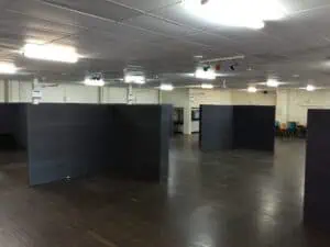 A spacious room with wooden flooring and multiple partitions, designed for events at Corinthian Booth rentals.