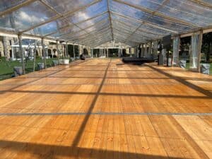 Interior view of a clear span marquee tent with a wooden floor.